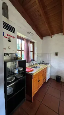 a kitchen with a black stove and a sink at Casita Lavanda - cercana a plaza de Villa de las Rosas con patio y asador in Villa de Las Rosas