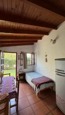 a bedroom with a bed and a table in a room at Casita Lavanda - cercana a plaza de Villa de las Rosas con patio y asador in Villa de Las Rosas