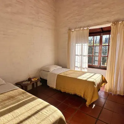a bedroom with two beds and a window at Casita Lavanda - cercana a plaza de Villa de las Rosas con patio y asador in Villa de Las Rosas