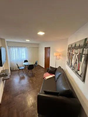 a living room with a black couch and a table at Paseo del Boulevard Suite in Cordoba