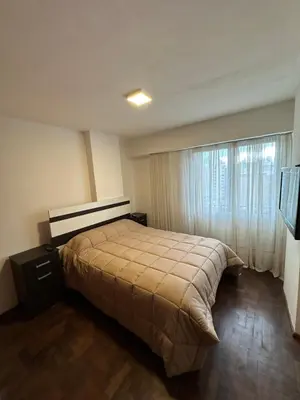 a bedroom with a bed and a large window at Paseo del Boulevard Suite in Cordoba