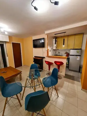 a kitchen with blue chairs and a table and a counter at Hermoso Dpto con Cochera en Nueva Cba!!!! in Cordoba