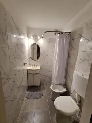 a white bathroom with a toilet and a sink at Hermoso Dpto con Cochera en Nueva Cba!!!! in Cordoba