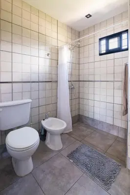 a bathroom with a toilet and a tub and a sink at La Floridita in Villa Ciudad Parque