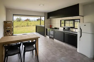 a kitchen with a table and a white refrigerator at La Floridita in Villa Ciudad Parque