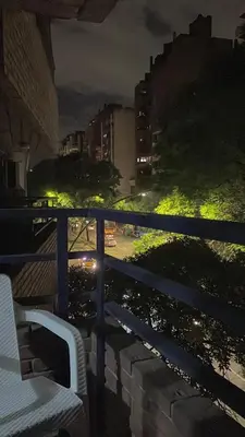 a white chair sitting on a balcony at night at Monoambiente en Nueva Córdoba in Cordoba