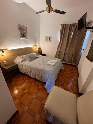 a bedroom with a bed and a ceiling fan at Chrome Hotel in Río Cuarto