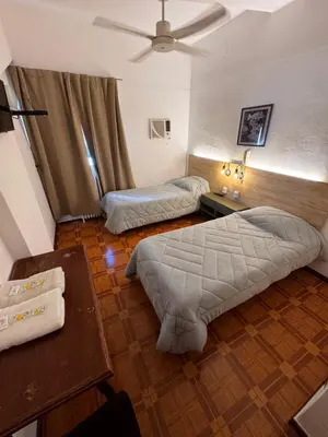 a bedroom with two beds and a table at Chrome Hotel in Río Cuarto