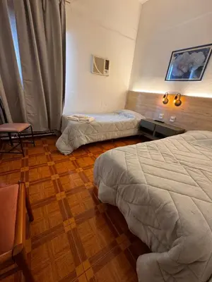 a hotel room with two beds and a table at Chrome Hotel in Río Cuarto