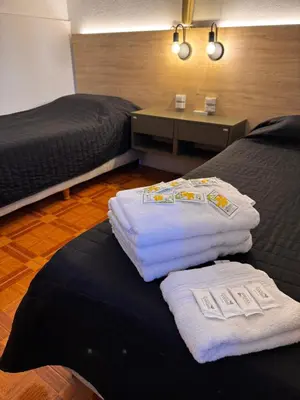 a hotel room with two beds and towels on a bed at Chrome Hotel in Río Cuarto