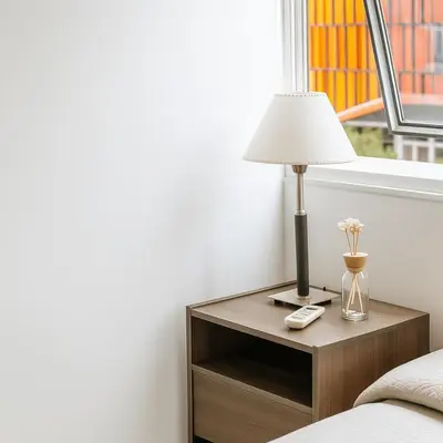 a table with a lamp on it next to a bed at Coral State Premium Tower in Cordoba