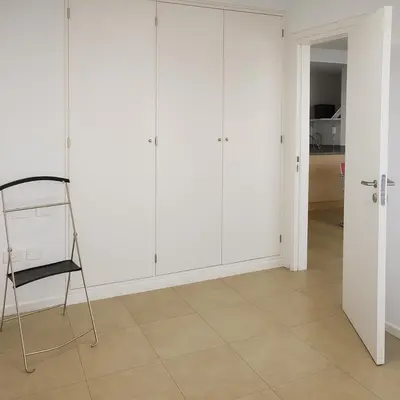 a room with white cabinets and a chair at Coral State Premium Tower in Cordoba