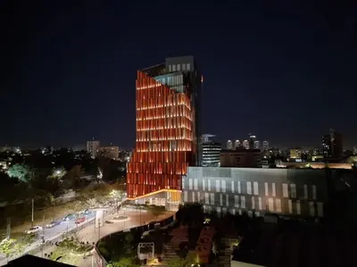 a tall building is lit up at night at Coral State Premium Tower in Cordoba