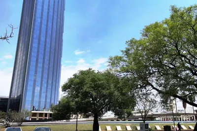 a tall building with a tree in front of it at Coral State Premium Tower in Cordoba