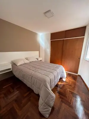 a bedroom with a large bed with a wooden floor at Tejas in Cordoba