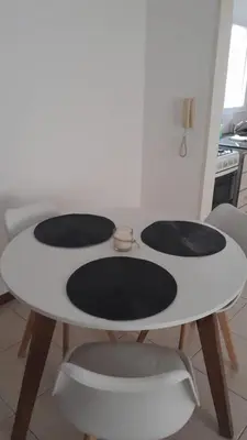 a white table with four black mats on it at Tejas in Cordoba