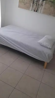 a bed sitting on a tiled floor in a room at Tejas in Cordoba