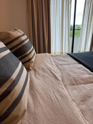 a bed with a pillow and a window in a room at Casa Raíz Cumbrecita in La Cumbrecita