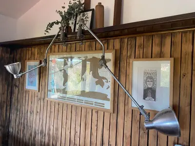a desk lamp hanging on a wall with pictures at Casa Raíz Cumbrecita in La Cumbrecita