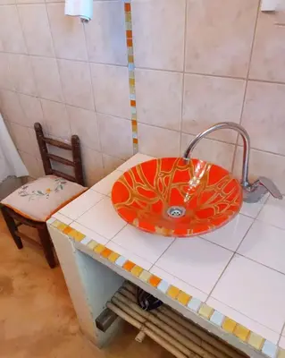 a bathroom with a red sink on a counter at Cabañas spa el petrel in San Javier