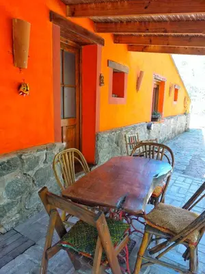 a wooden table and chairs in front of a house at Cabañas spa el petrel in San Javier