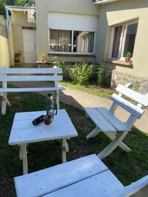 a picnic table and two benches in front of a house at La Casita Yogui in Santa Rosa de Calamuchita