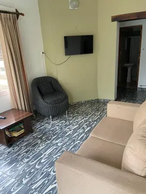 a living room with a couch and a chair and a television at La Casita Yogui in Santa Rosa de Calamuchita