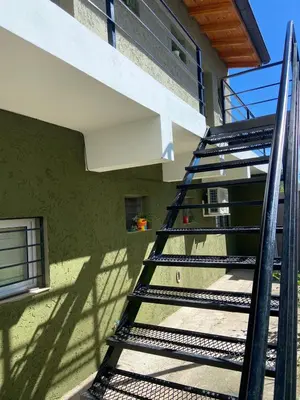 a staircase leading up to a green building at La Casita Yogui in Santa Rosa de Calamuchita