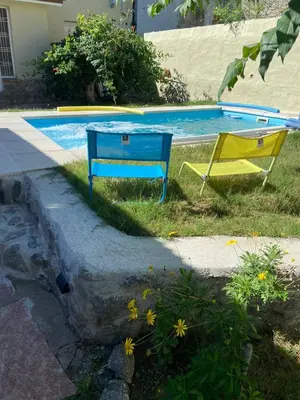 a blue and yellow bench next to a swimming pool at La Casita Yogui in Santa Rosa de Calamuchita