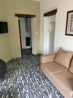 a living room with a couch and a bedroom at La Casita Yogui in Santa Rosa de Calamuchita