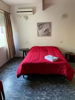 a bedroom with a red bed in a room at La Casita Yogui in Santa Rosa de Calamuchita