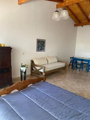 a bedroom with a bed and a bench and a table at La Casita Yogui - MONOAMBIENTE 2 in Santa Rosa de Calamuchita