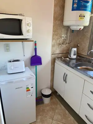a small kitchen with a microwave and a refrigerator at La Casita Yogui - MONOAMBIENTE 2 in Santa Rosa de Calamuchita