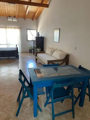 a blue table in a living room with a couch at La Casita Yogui - MONOAMBIENTE 2 in Santa Rosa de Calamuchita