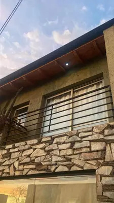 a house with a stone wall with a balcony at La Casita Yogui - MONOAMBIENTE 2 in Santa Rosa de Calamuchita