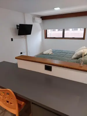 a bed in a small room with a desk and a desk at Departamento 3 Paris - Edificio VILAUT by INMOVE Temporarios in Cordoba