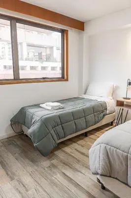 a bedroom with two beds and a window at Departamento 3 Paris - Edificio VILAUT by INMOVE Temporarios in Cordoba
