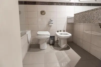 a white bathroom with a toilet and a sink at Departamento 3 Paris - Edificio VILAUT by INMOVE Temporarios in Cordoba