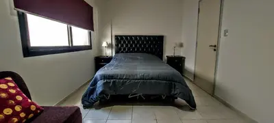 a bedroom with a bed and a window and a chair at Oasis depto en centro carlos paz in Villa Carlos Paz