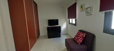 a living room with a chair and a television at Oasis depto en centro carlos paz in Villa Carlos Paz