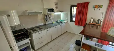 a small kitchen with a stove and a refrigerator at Oasis depto en centro carlos paz in Villa Carlos Paz