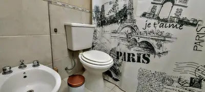 a bathroom with a white toilet and a sink at Oasis, departamento en Carlos paz in Villa Carlos Paz