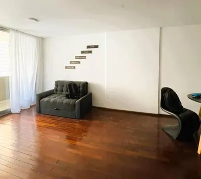 a living room with a black couch and a staircase at Elegante en B° General Paz in Cordoba