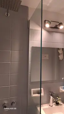 a bathroom with a shower with a sink and a mirror at AL TOQUE DEL OLMOS Luminoso y confortable in Cordoba