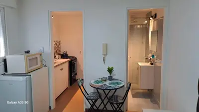 a kitchen with a small table and a kitchen with a refrigerator at AL TOQUE DEL OLMOS Luminoso y confortable in Cordoba