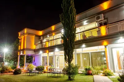 a building with tables and chairs in front of it at night at Nuevo Hotel Carmel in Villa Carlos Paz