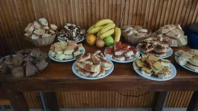 a table full of different types of food on plates at Nuevo Hotel Carmel in Villa Carlos Paz