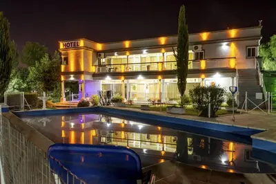 a hotel with a swimming pool in front of a building at Nuevo Hotel Carmel in Villa Carlos Paz