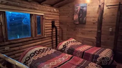 a bedroom with two beds in a log cabin at Cabaña La Fortaleza Villa Yacanto in Villa Yacanto