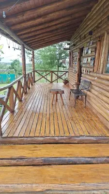 a wooden porch of a cabin with a bench on it at Cabaña La Fortaleza Villa Yacanto in Villa Yacanto
